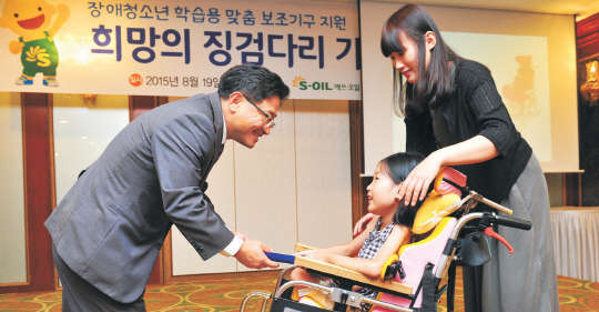 19일 경기도 수원 경기도재활공학서비스연구지원센터에서 열린 '에쓰오일 저소득가정 장애청소년 학습용 맞춤 보조기구 전달식'에서 이창재 에쓰오일 부사장(왼쪽)이 수혜 학생에게 맞춤형 학습 보조기구를 전달하고 있다. 에쓰오일 제공